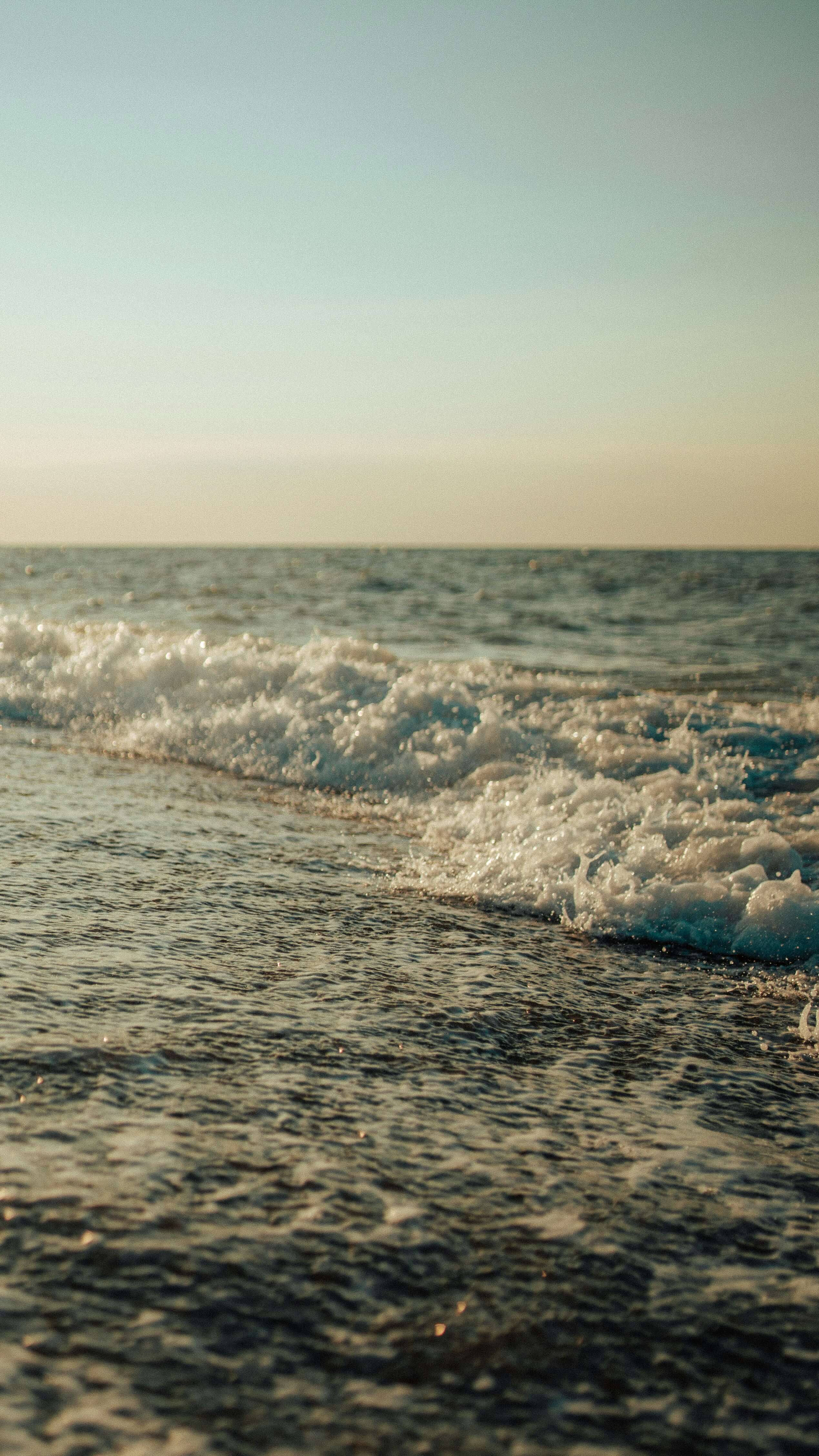 a photo of small waves during a sunset