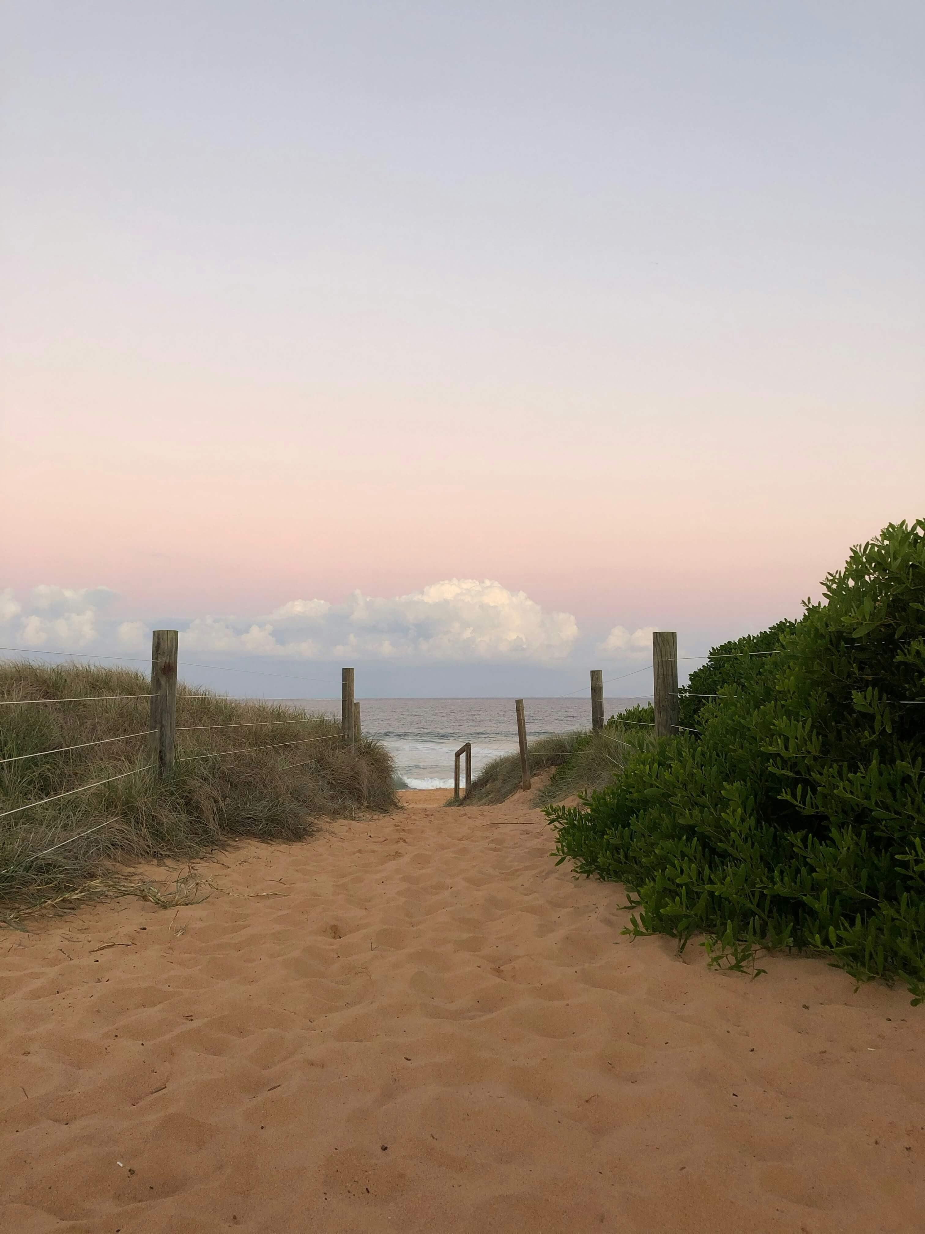 a photo of sand and hills facing the beach at sunset