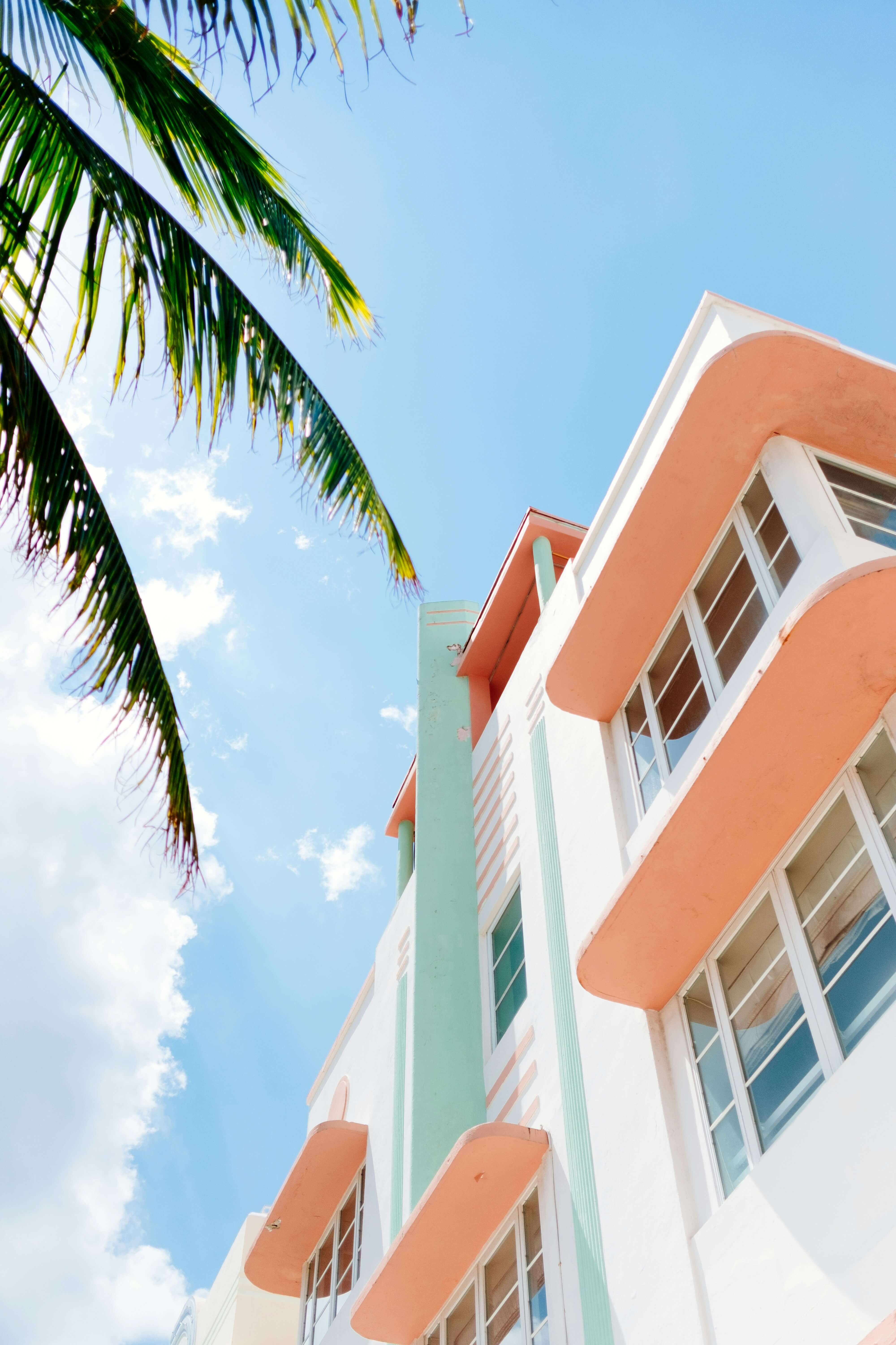 a photo of the side of a hotel with pastel colors facing up to a blue sky