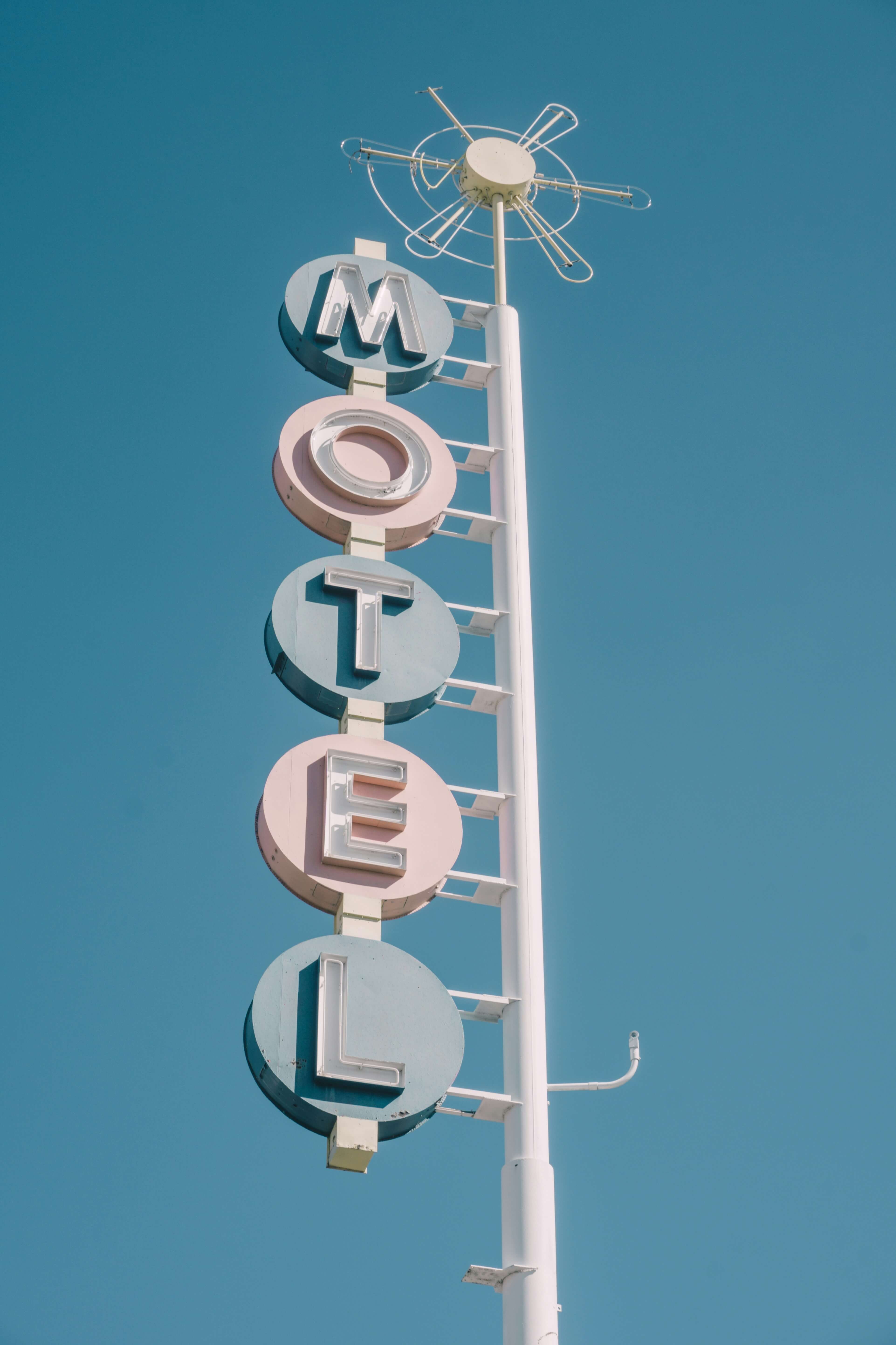 a photo of a old roadside motel sign with faded blue and red below each of the letters