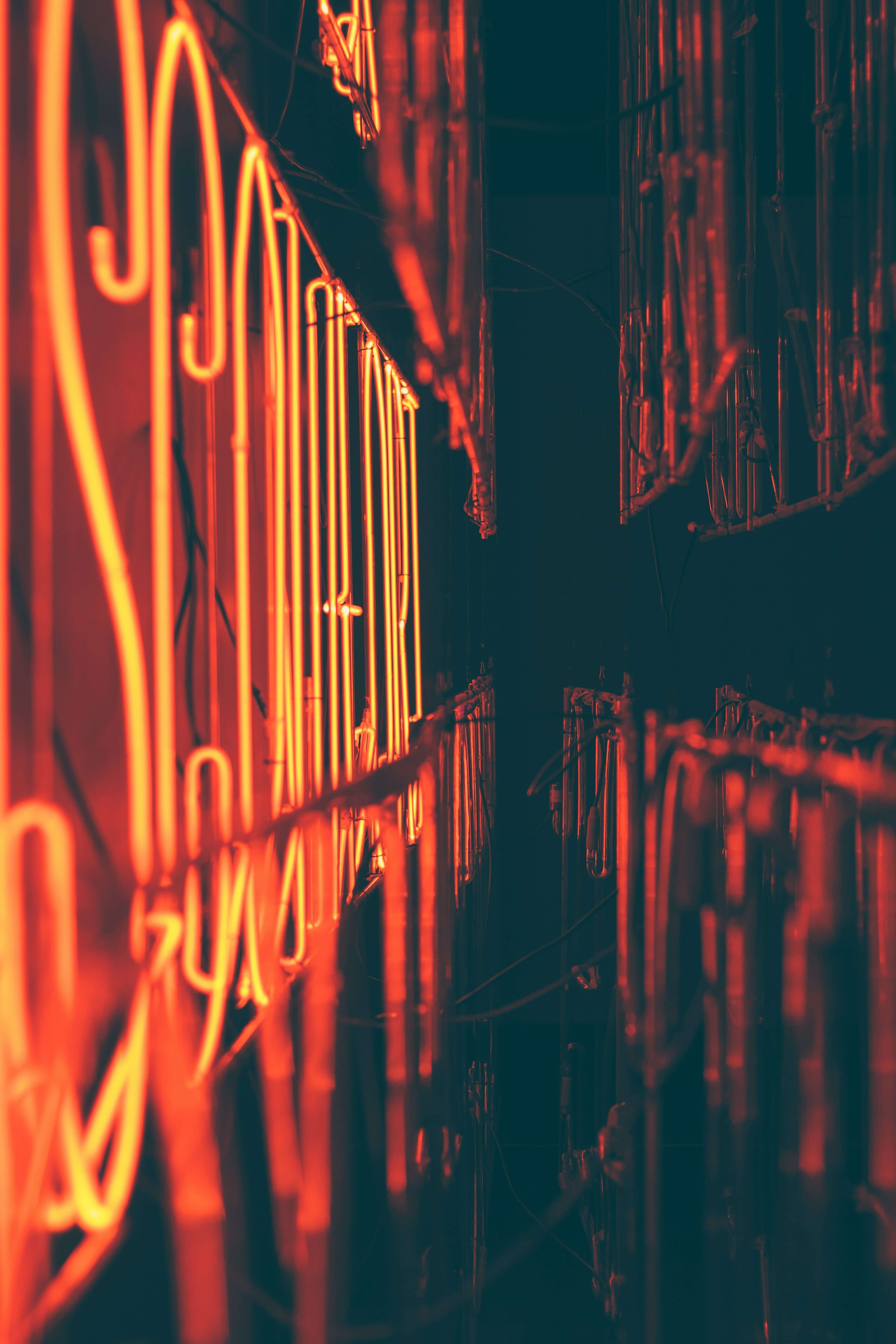 a photo of various bits of orange neon in a dark background