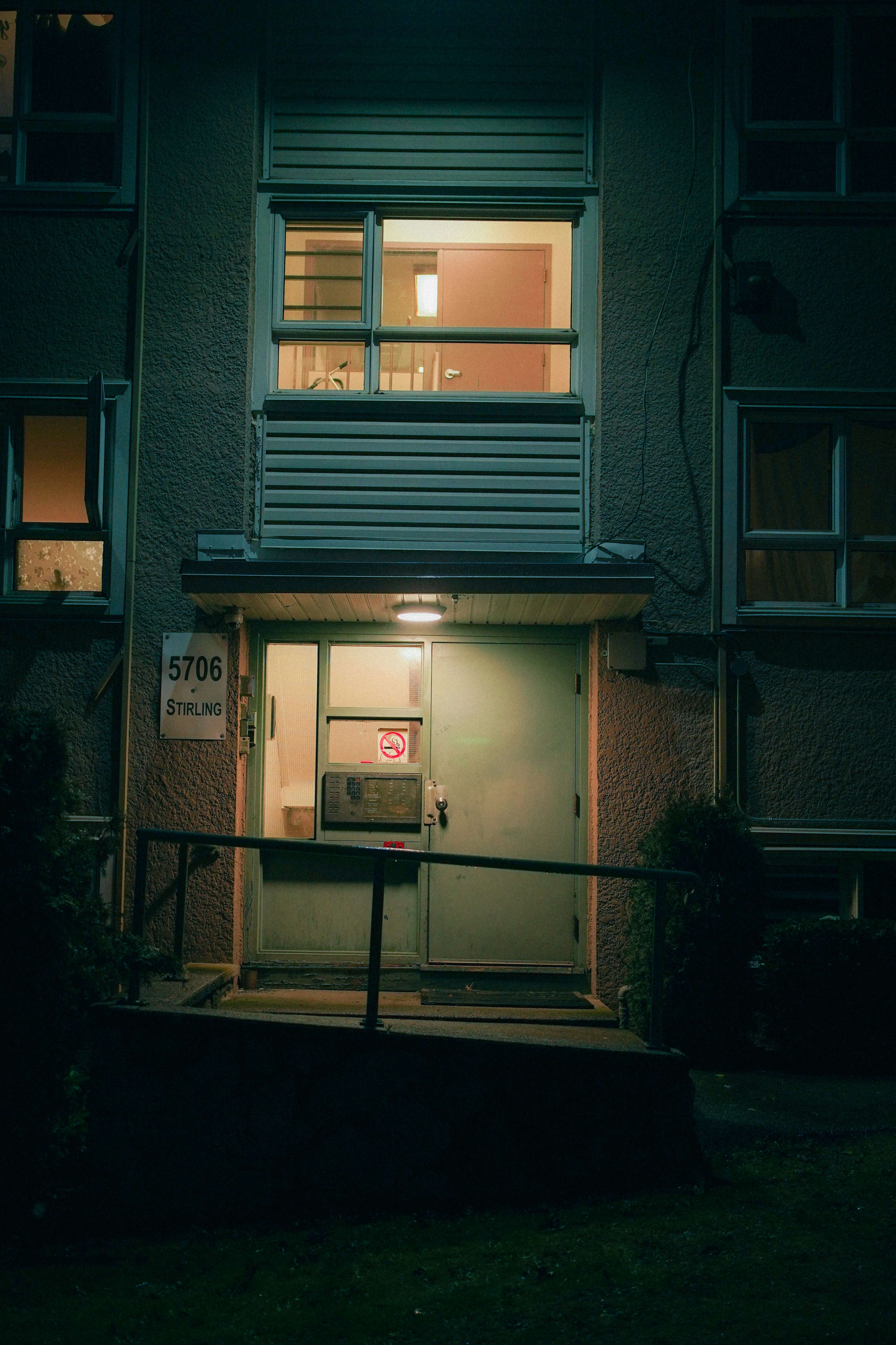 a photo of a side entrance to an apartment at night