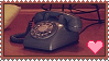 a image of a blue rotary phone on a red carpet with a heart on the right