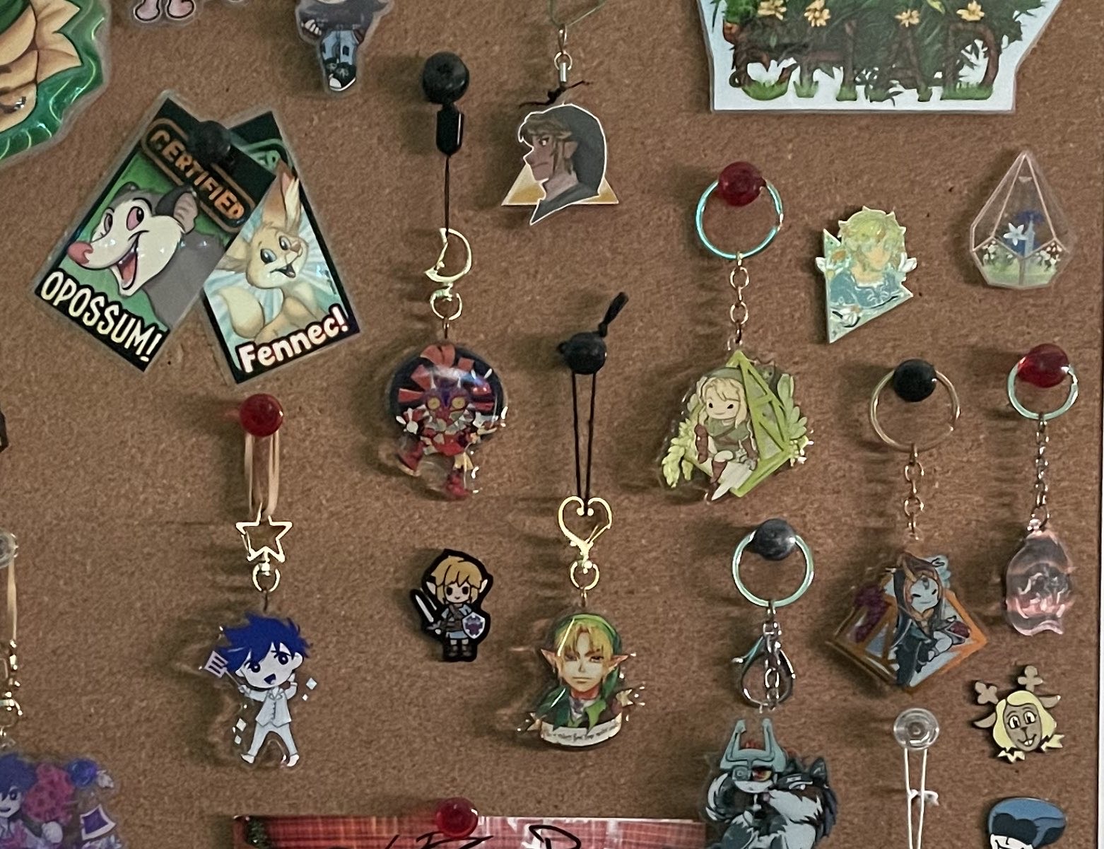 A cork board featuring various zelda charms and pins